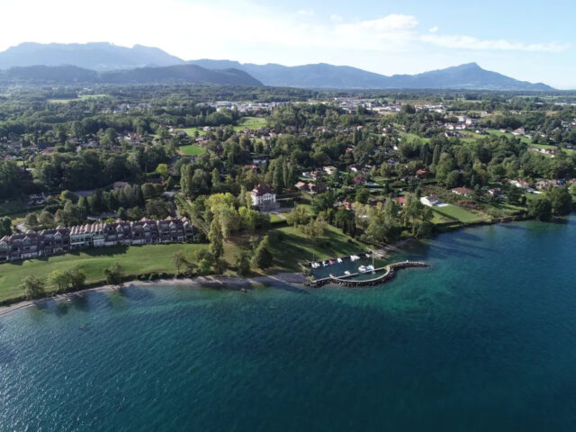 vue aérienne d'anthy sur léman au bord du lac, montagnes en fond